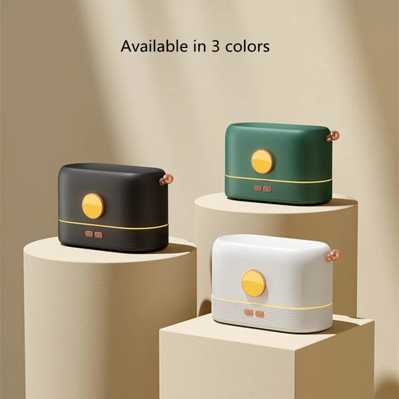 Black USB-powered humidifier with simulated orange flame effect and mist on a wooden desk.
