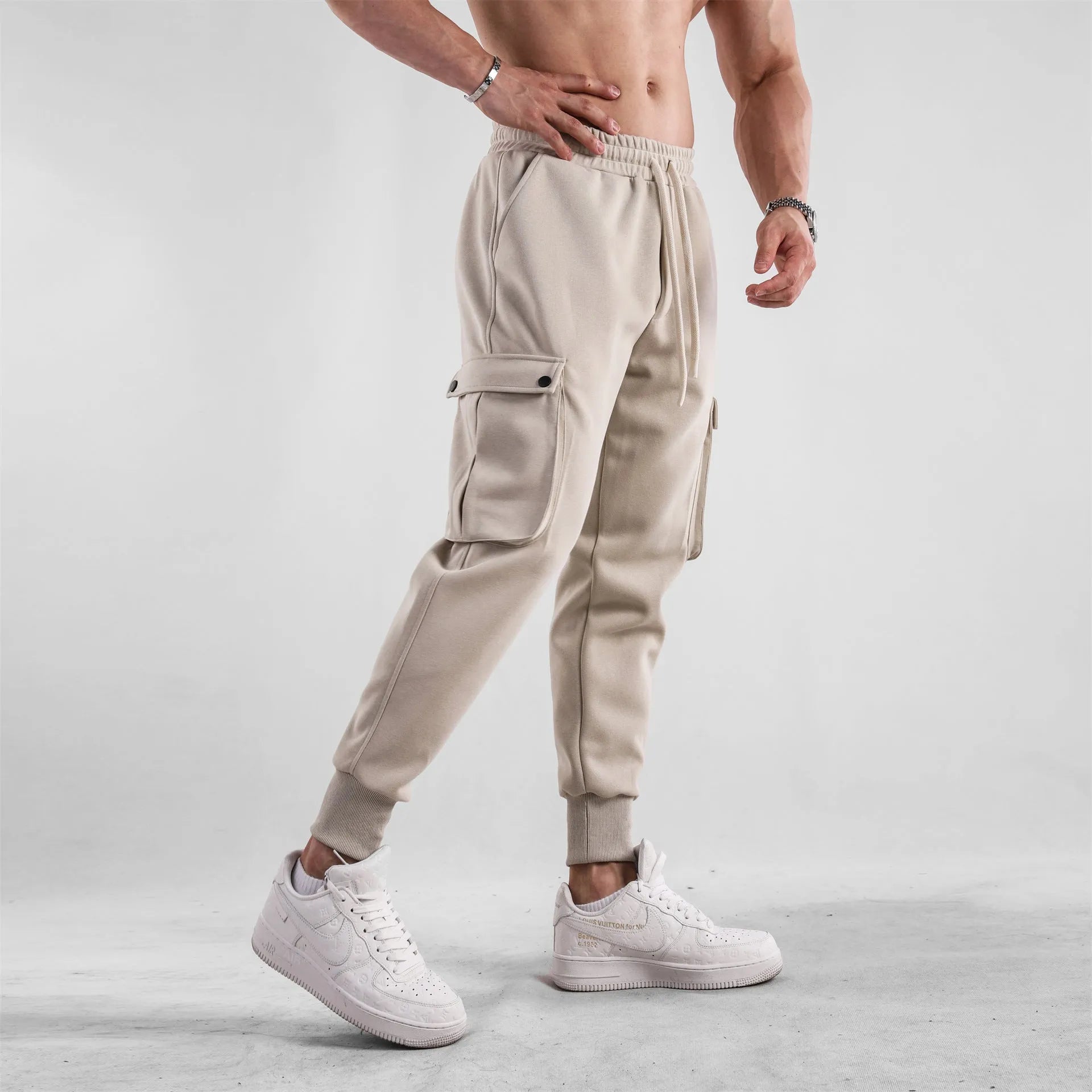 Men's loose ankle-tied cotton sports trousers in multi-pocket design showing apricot colour option