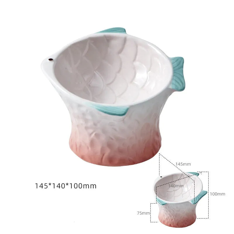Blue fish-shaped ceramic cat bowl with tilted angle and elevated sides on a white background.