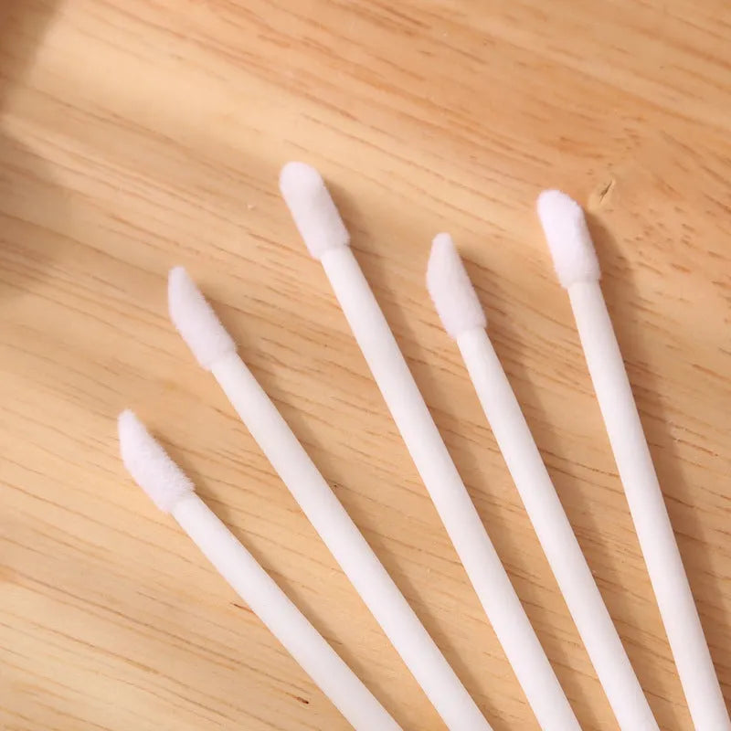 Disposable lip brushes with black handles and flocked tips in bulk packaging for lipstick and gloss application