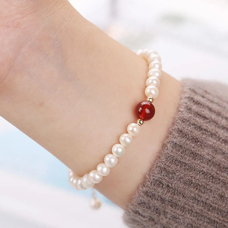 A Chinese style glass bracelet with bamboo leaf and bead designs on a wrist.