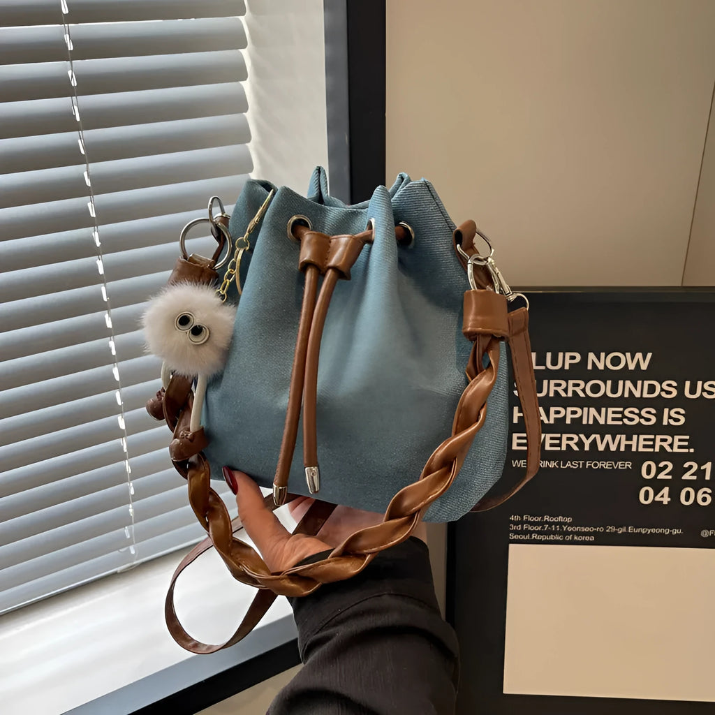 Blue synthetic leather cross-body bucket bag with adjustable strap and optional hanging drop decoration