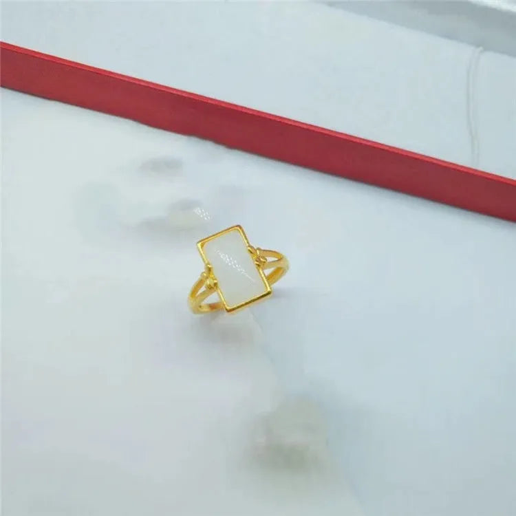 Adjustable brass gold-plated ring with an electroplated finish and a choice of black, green, or white gemstone.