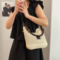 Knitted tote beach bag in bucket shape with contrast stitching and crossbody strap