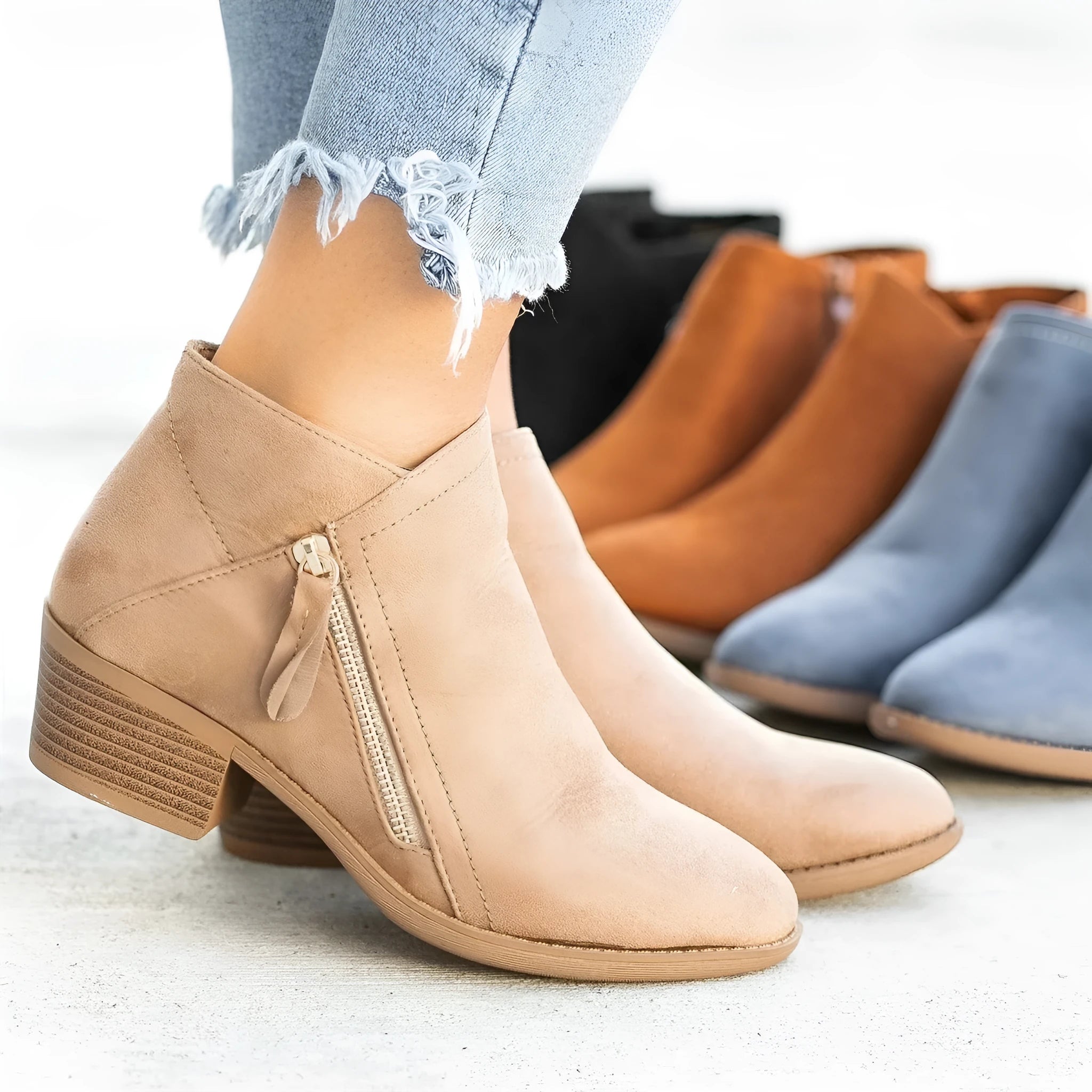 Women's blue suede ankle boots with a side zip and chunky heel, shown on a foot.