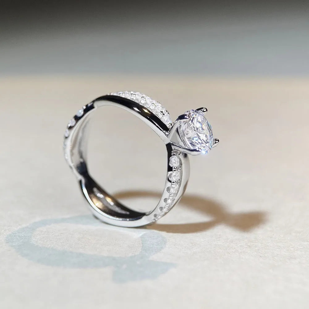 Geometric cross-design silver ring with a 1 karat moissanite stone in a four-claw setting.