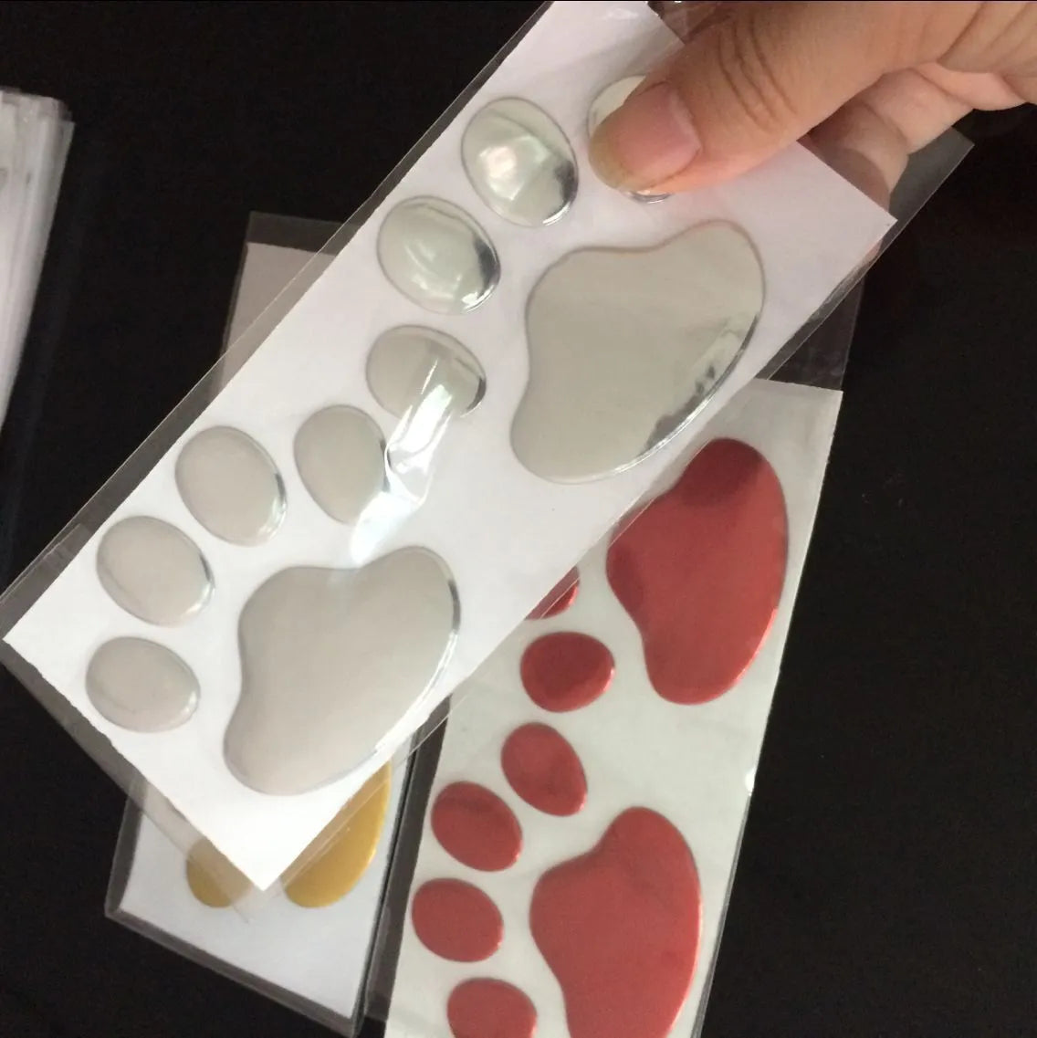 PVC dog footprint car sticker in black, gold, red, and silver colour options, measuring 7cm.