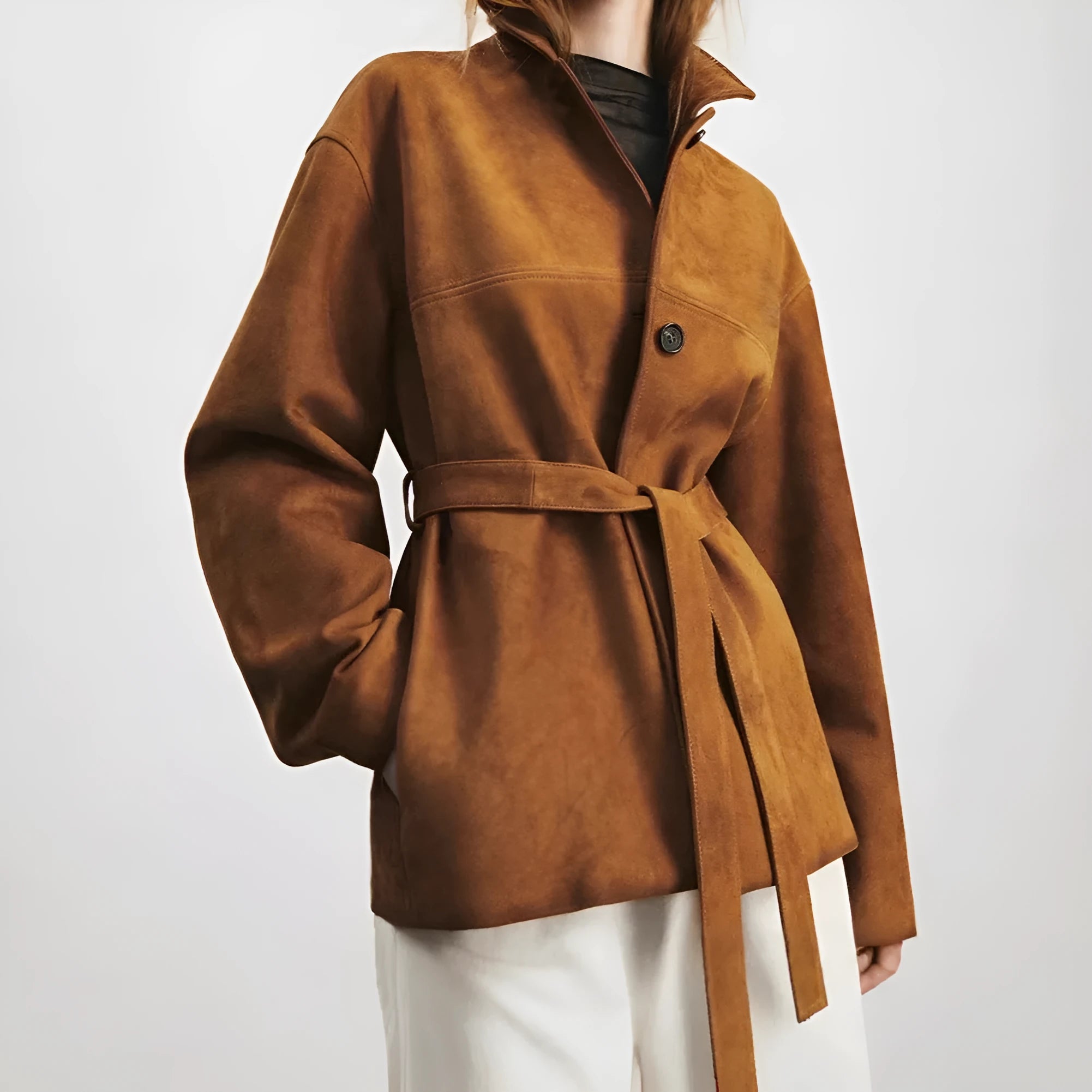 Women's caramel mocha cashmere coat with Peter Pan collar and belt, showing leather stitching and loose retro fit.
