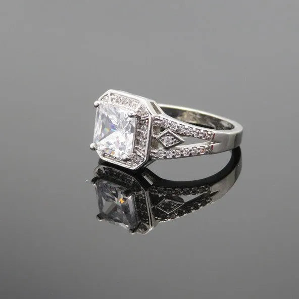 Platinum-colour zircon ring with hollow geometric quadrilateral design on a copper base