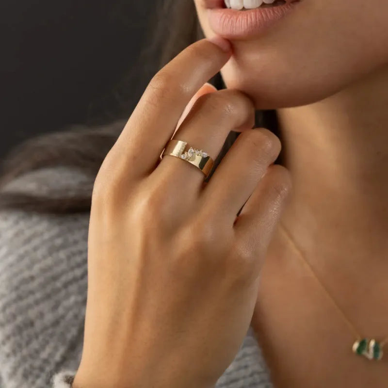 Gold-coloured electroplated copper band ring for women shown on a finger.