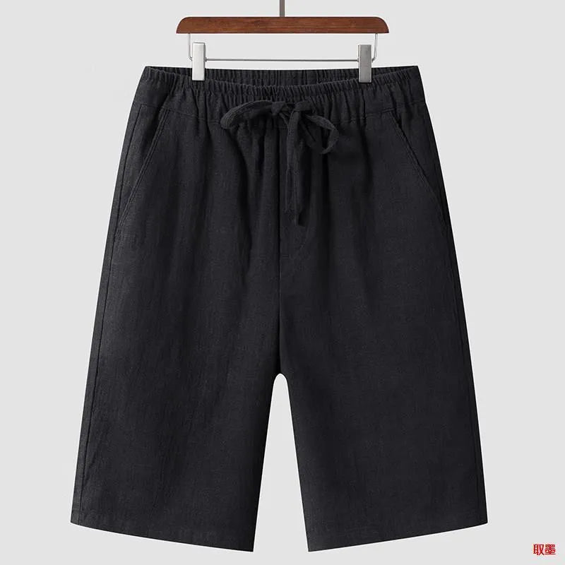 Men's beige linen shorts with loose cropped fit and elasticated waistband laid flat.
