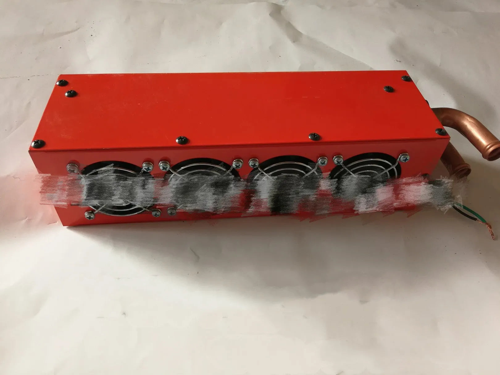 Small metal car heater core unit with copper pipes and electrical connections for 12V 24V installation.