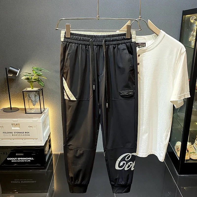 Men's solid black cropped trousers with banded ankle cuffs made from thin ice silk cotton fabric.