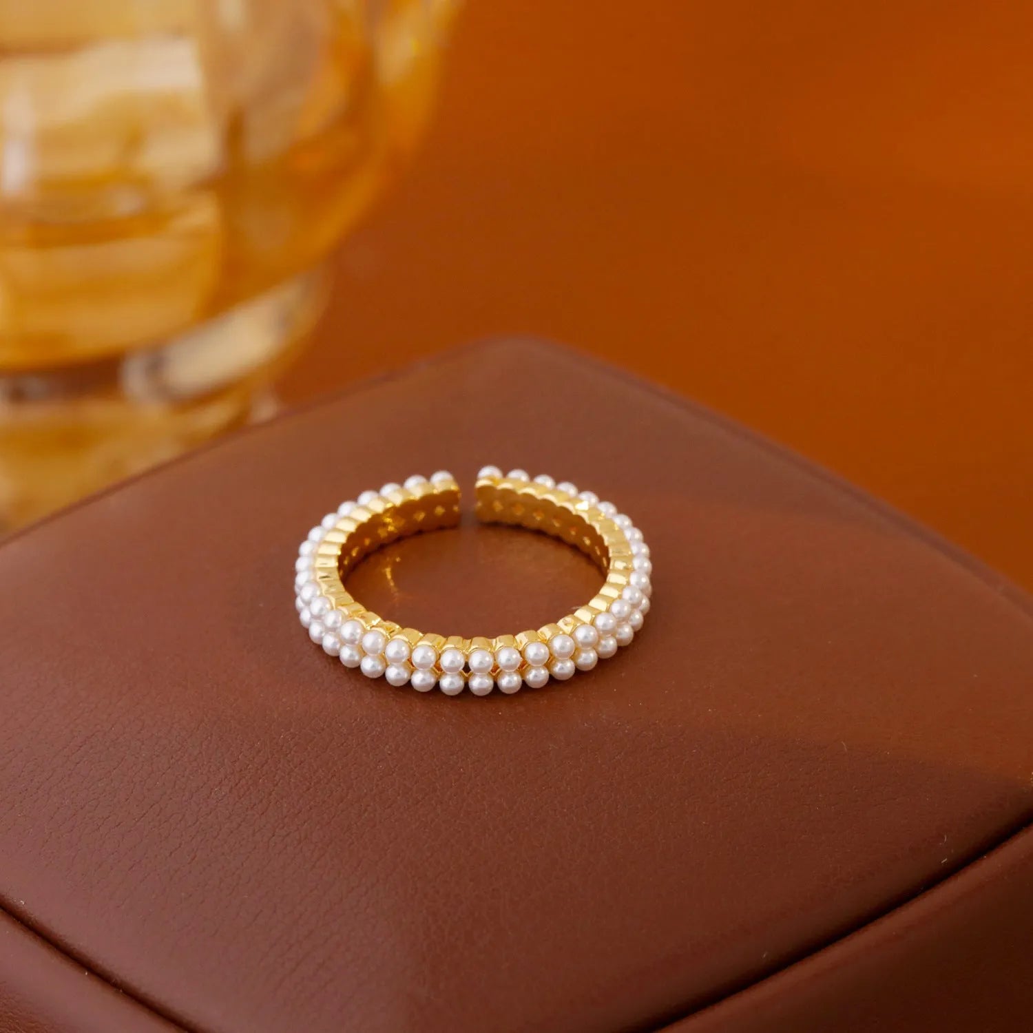 Gold coloured women's ring with open mouth design and round pearl elements on copper electroplated construction