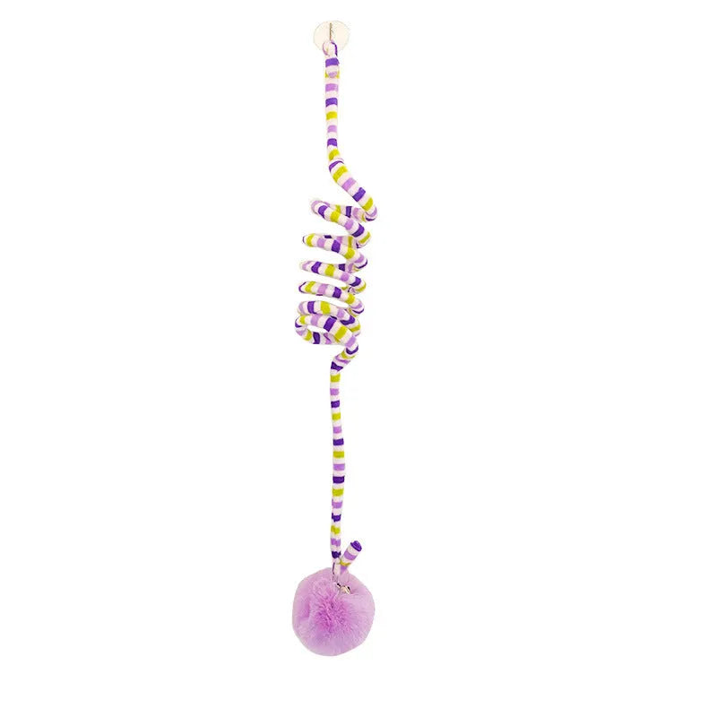 Colourful suction cup cat toy with spring wand and inflatable ball, hanging on a glass door