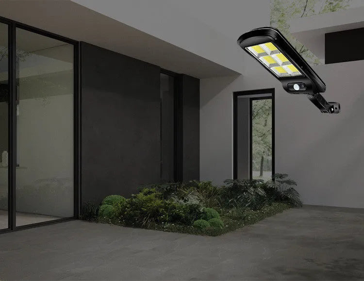 Black outdoor solar motion sensor light for garden or pathway mounting.
