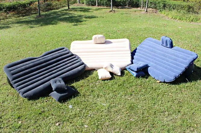 Black inflatable car bed with flocking material and two pillows, shown inside a car.