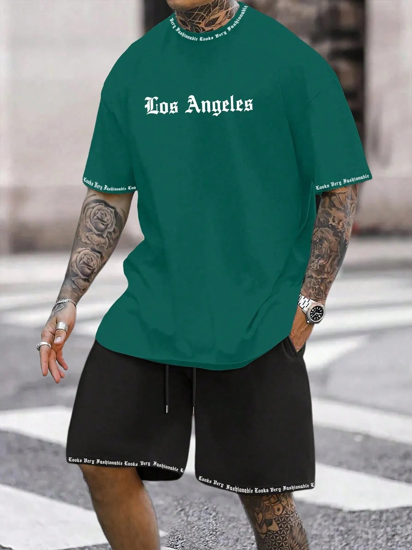 Man wearing a grey short-sleeve top and matching shorts from a sports co-ord set.