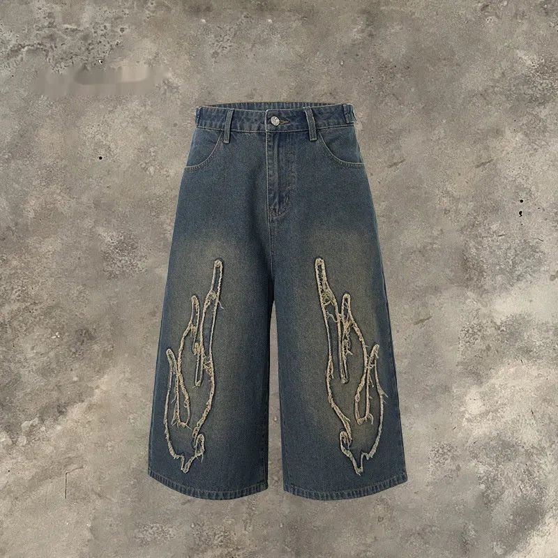Men's black cropped denim shorts with flame embroidery patch and straight-leg cut