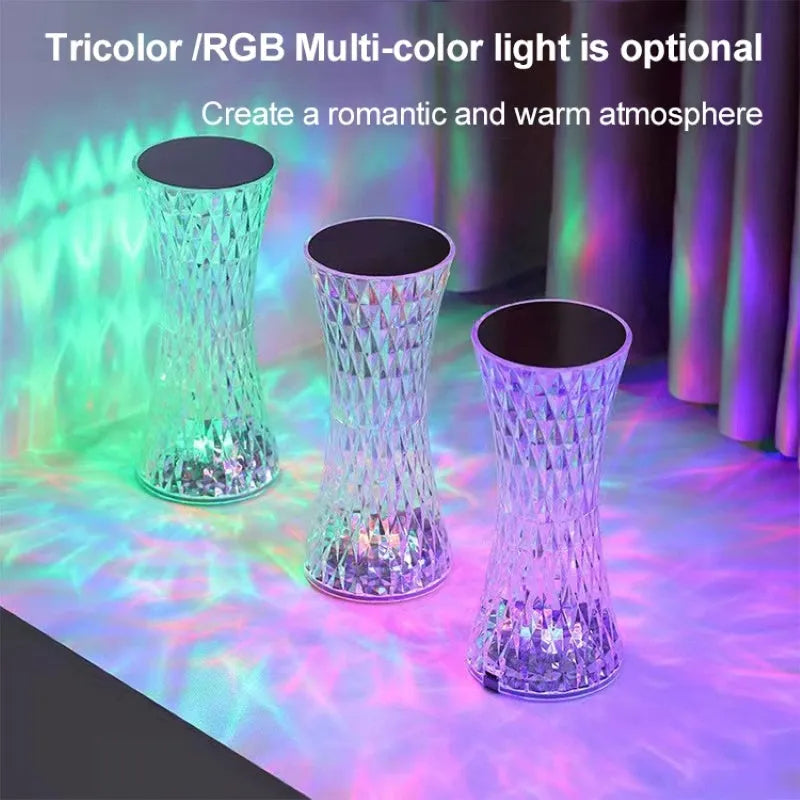 White crystal vase-shaped table lamp with remote control on a wooden surface.