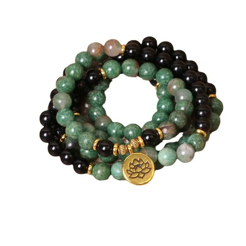 Green and black alloy bead elastic stretch bracelet on a wrist.