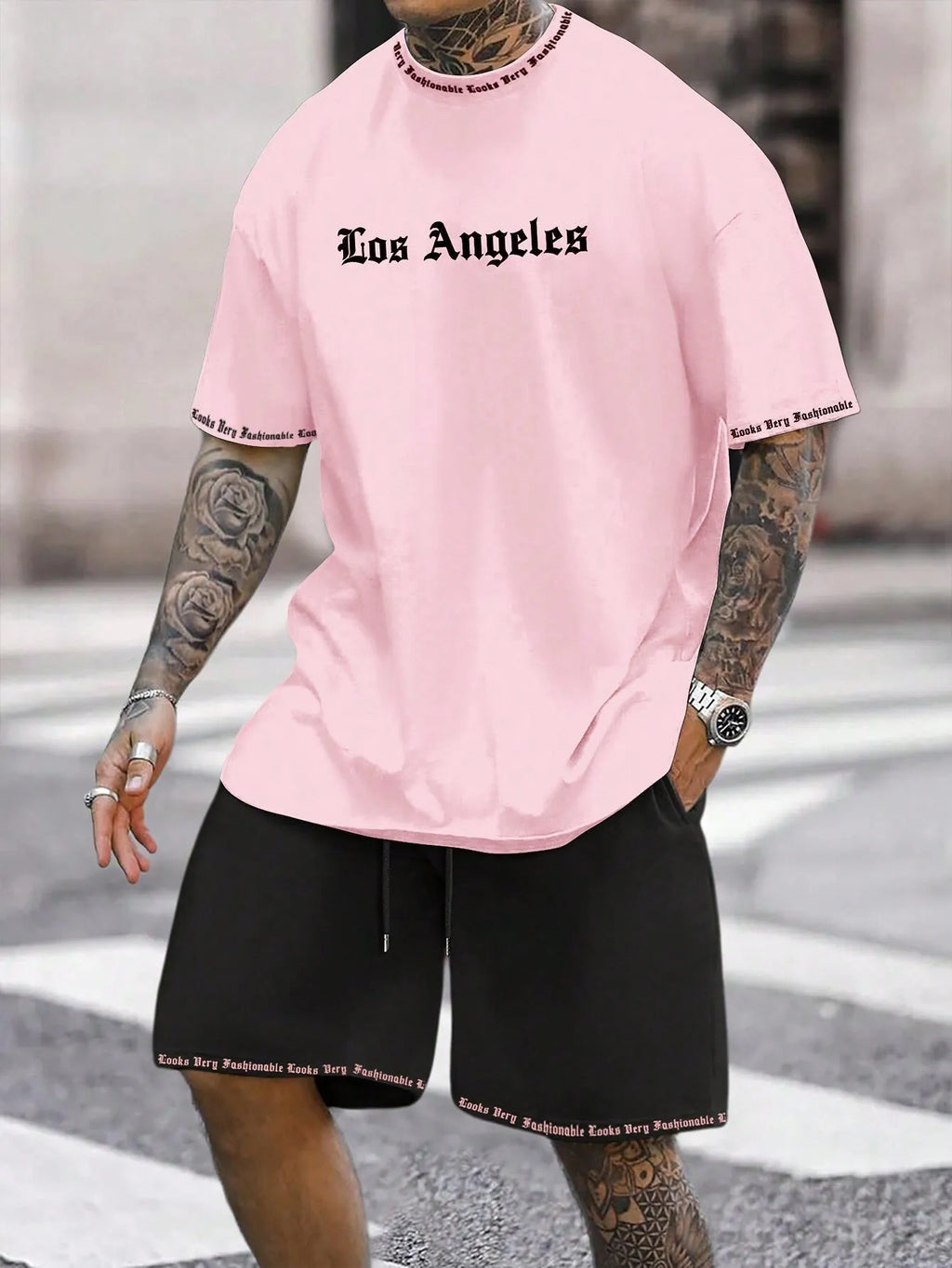 Man wearing a grey short-sleeve top and matching shorts from a sports co-ord set.
