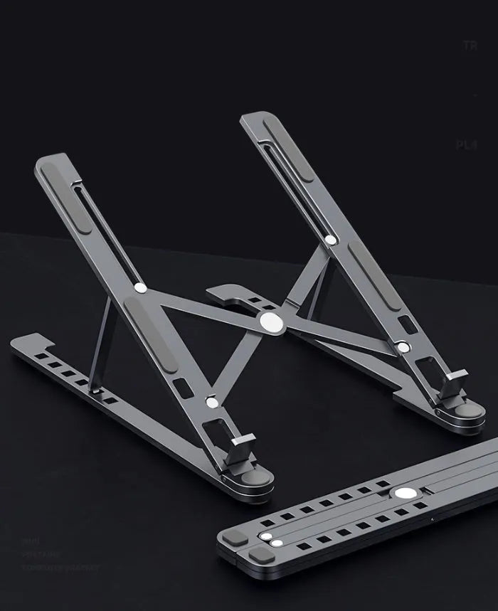 Aluminium laptop stand folded flat next to an open laptop showing adjustable height settings.