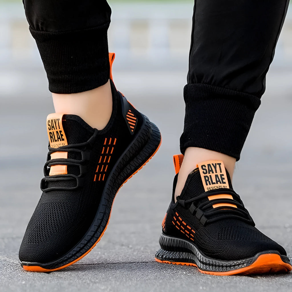 Men's black casual sports shoes with stripe and cross-strap detail on a Flying Weave upper.