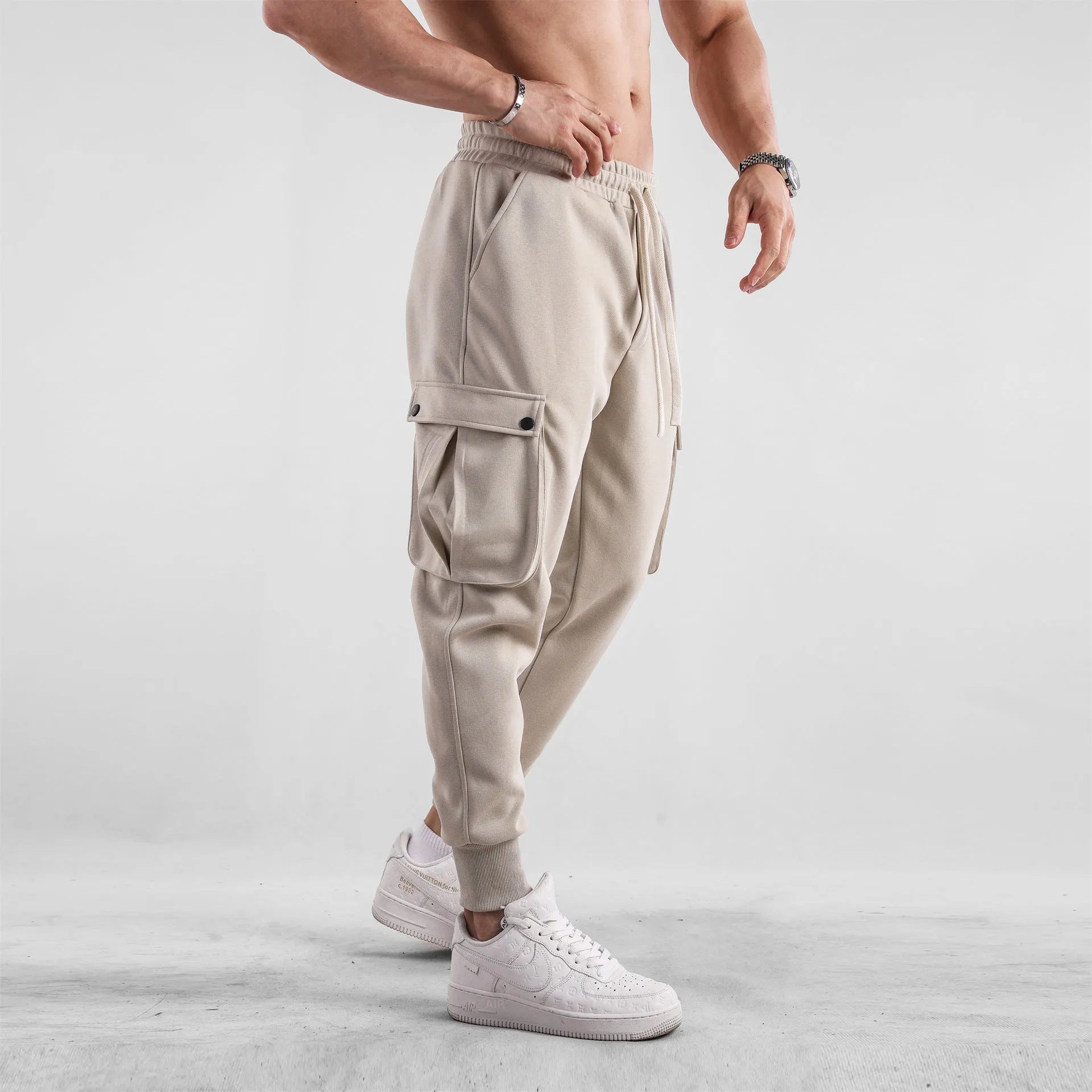 Men's loose ankle-tied cotton sports trousers in multi-pocket design showing apricot colour option