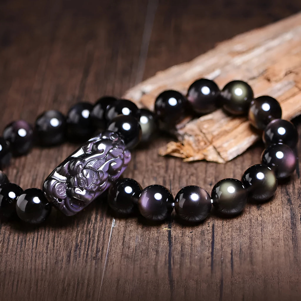 Geometric Pi Xiu charm on a polished icy obsidian crystal bracelet for men and women.