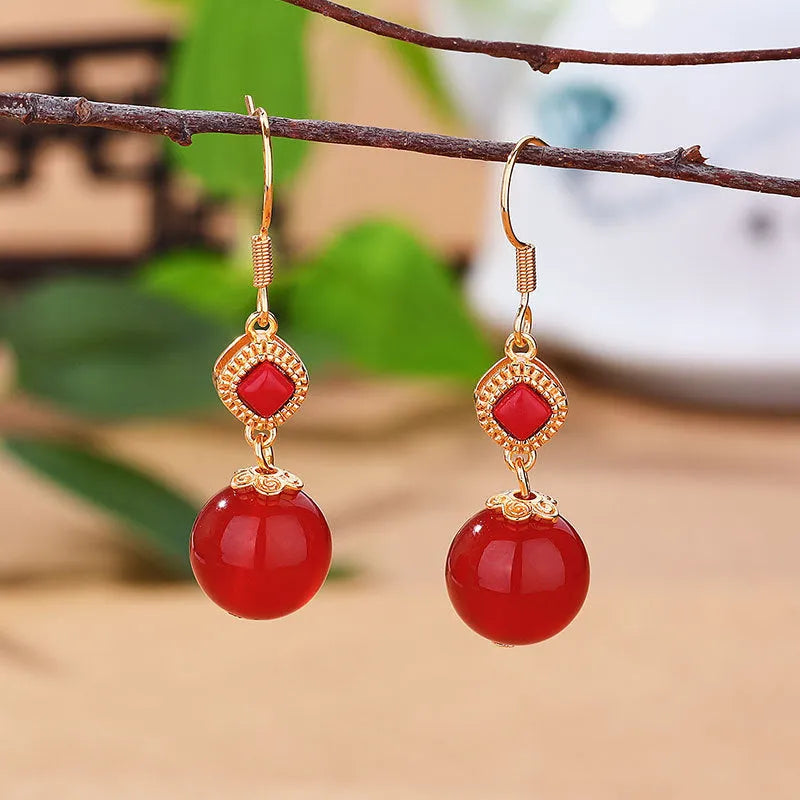 Geometric copper alloy earrings with a round Southern Red Agate bead and S925 sterling silver inlay details.