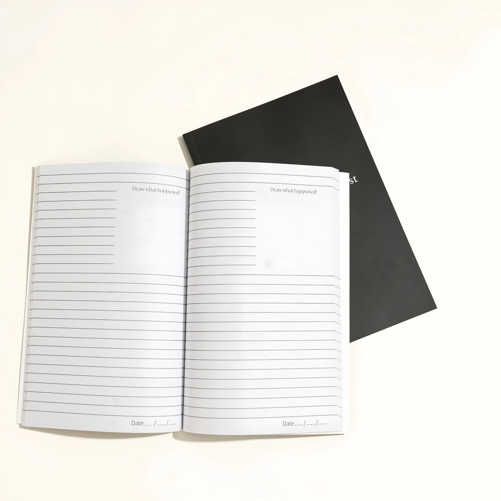 Black hardcover A5 dream journal notebook with plain paper pages open