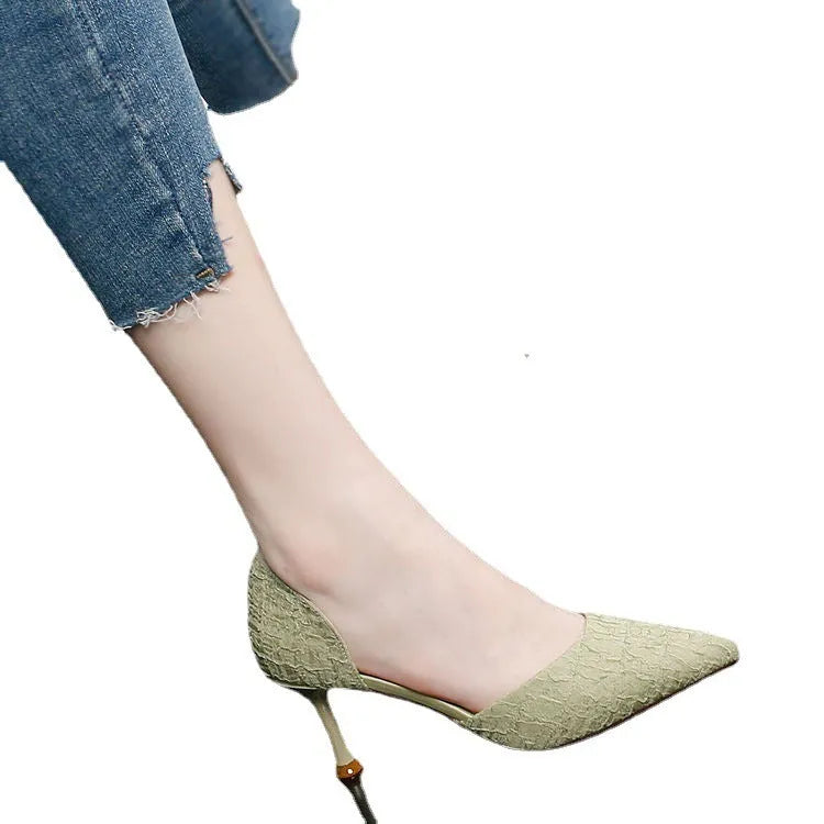 Women's black pointed high heel shoes with stiletto heel on neutral background