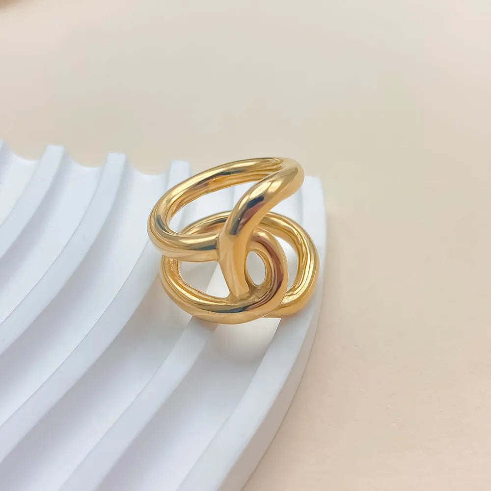 Adjustable knotted women's ring in stainless steel with geometric U-shape, shown in gold and steel colours.