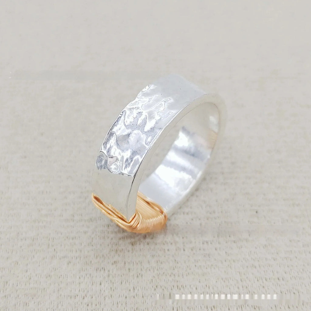 Geometric copper bracelet with irregular coil design and silver-gold electroplated finish.