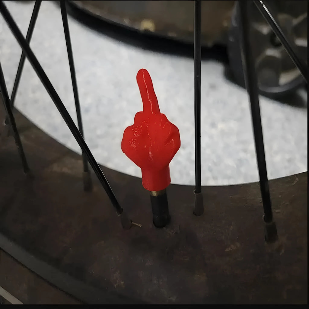 Eight car tyre valve caps, four black and four skin colour, made from latex.
