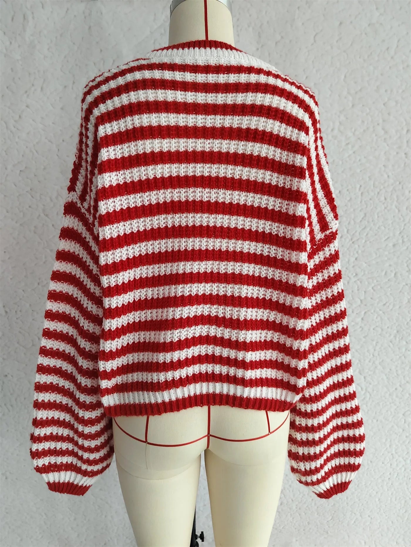 Woman wearing loose striped knit sweater in vintage style with round neck and long sleeves