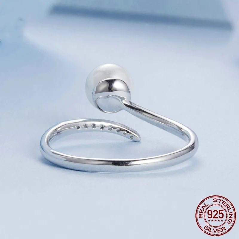 Adjustable sterling silver ring for women with a central shell pearl on an open-loop band.