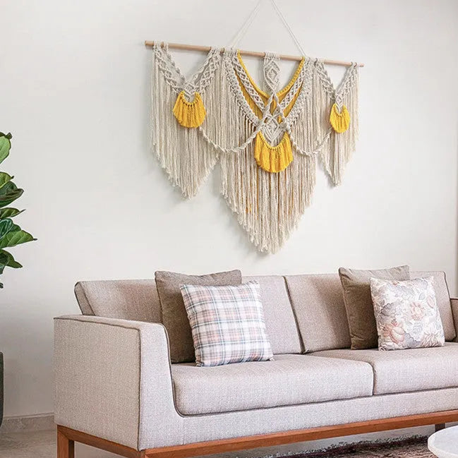 Hand-woven creamy white and yellow Nordic style cotton tapestry hanging on a wall