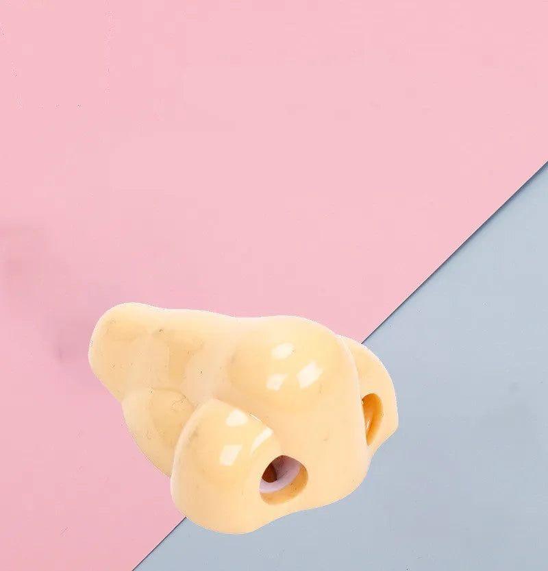 Flesh coloured plastic geometry design pencil sharpener with large casing, shown alongside a pencil.