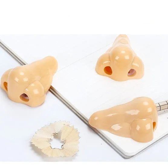 Flesh coloured plastic geometry design pencil sharpener with large casing, shown alongside a pencil.