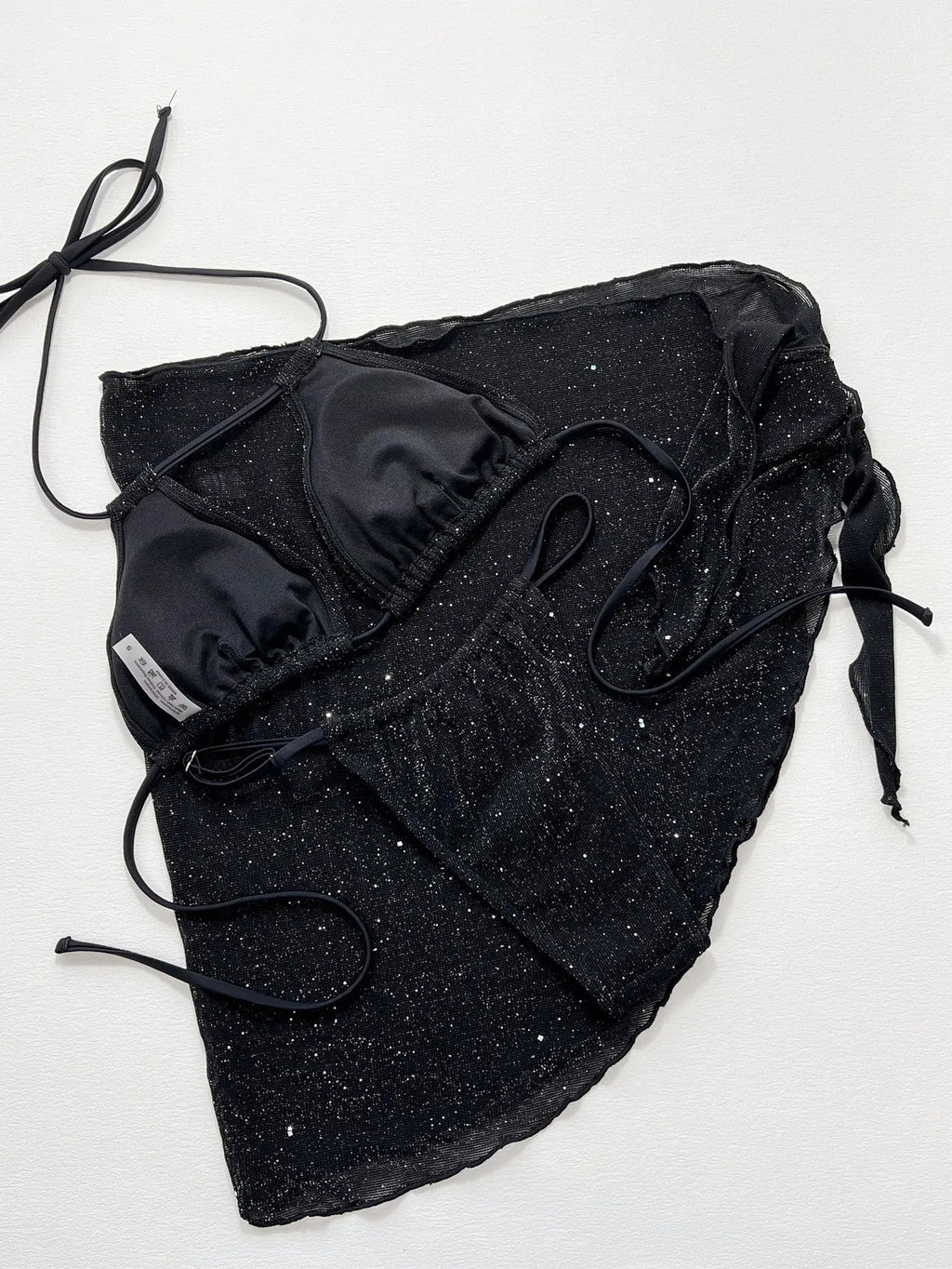 Black women's three-piece ruffled bikini set with matching shorts on a mannequin.