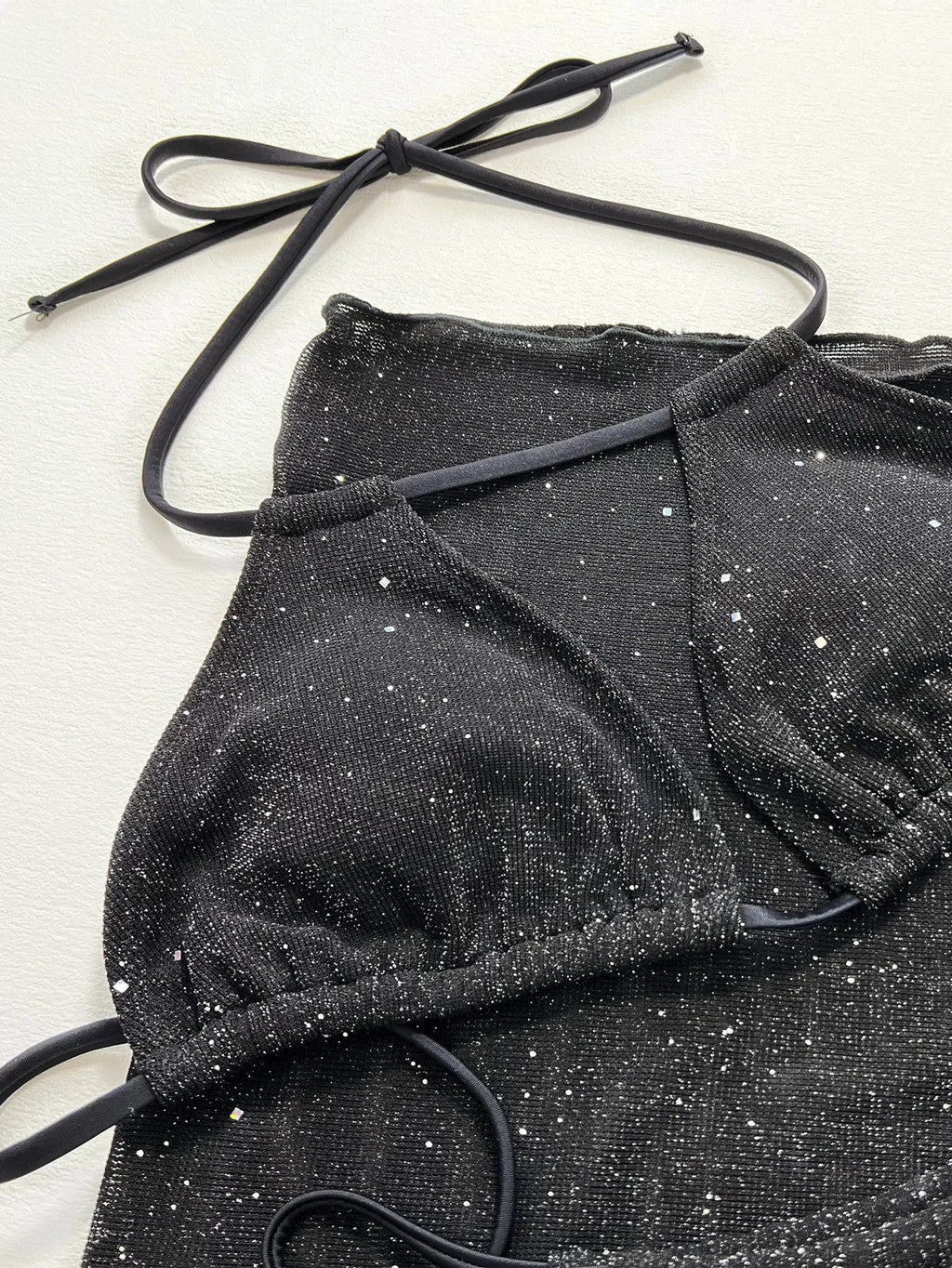 Black women's three-piece ruffled bikini set with matching shorts on a mannequin.