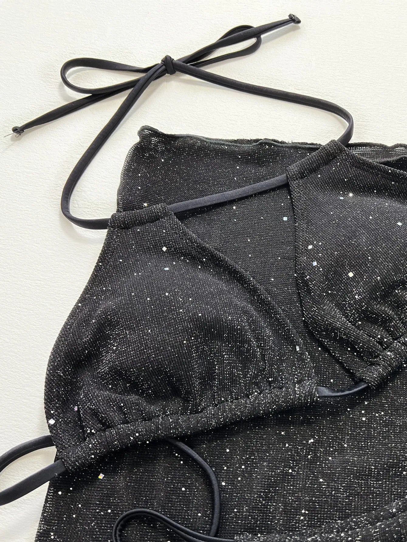 Black women's three-piece ruffled bikini set with matching shorts on a mannequin.