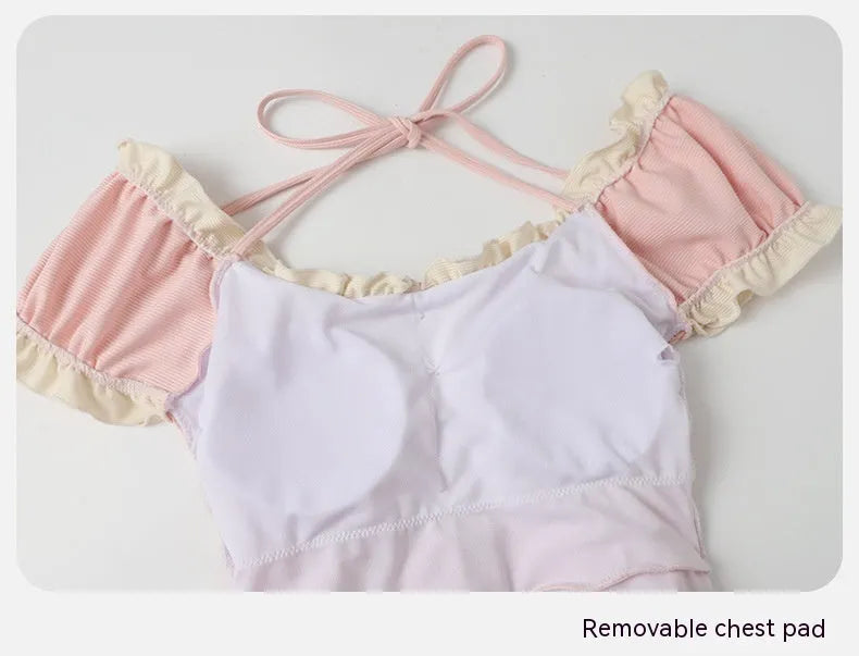 Pink women's conservative one-piece swimsuit with a Siamese cute design on a mannequin