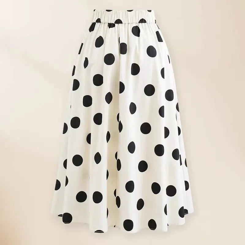Women's black one-piece swimsuit with a white bow and round skirt on a mannequin, front view.