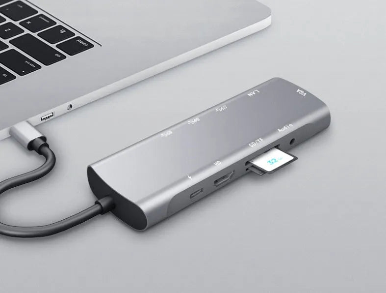 Grey aluminium USB-C docking station with HDMI, VGA, USB ports, and a short connecting cable