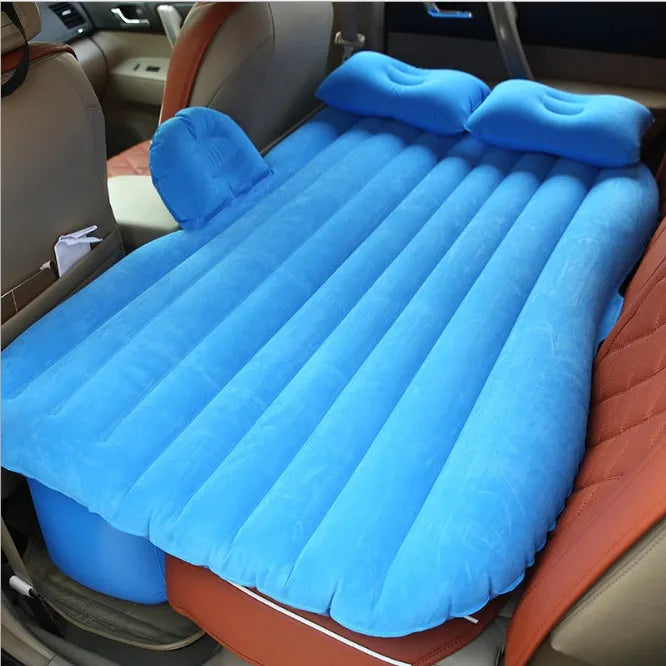Black inflatable car bed with flocking material and two pillows, shown inside a car.