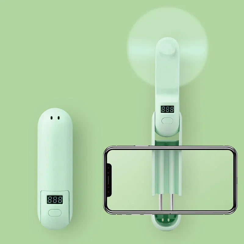 Green folding mini fan with plastic blades, shown in open and closed positions.
