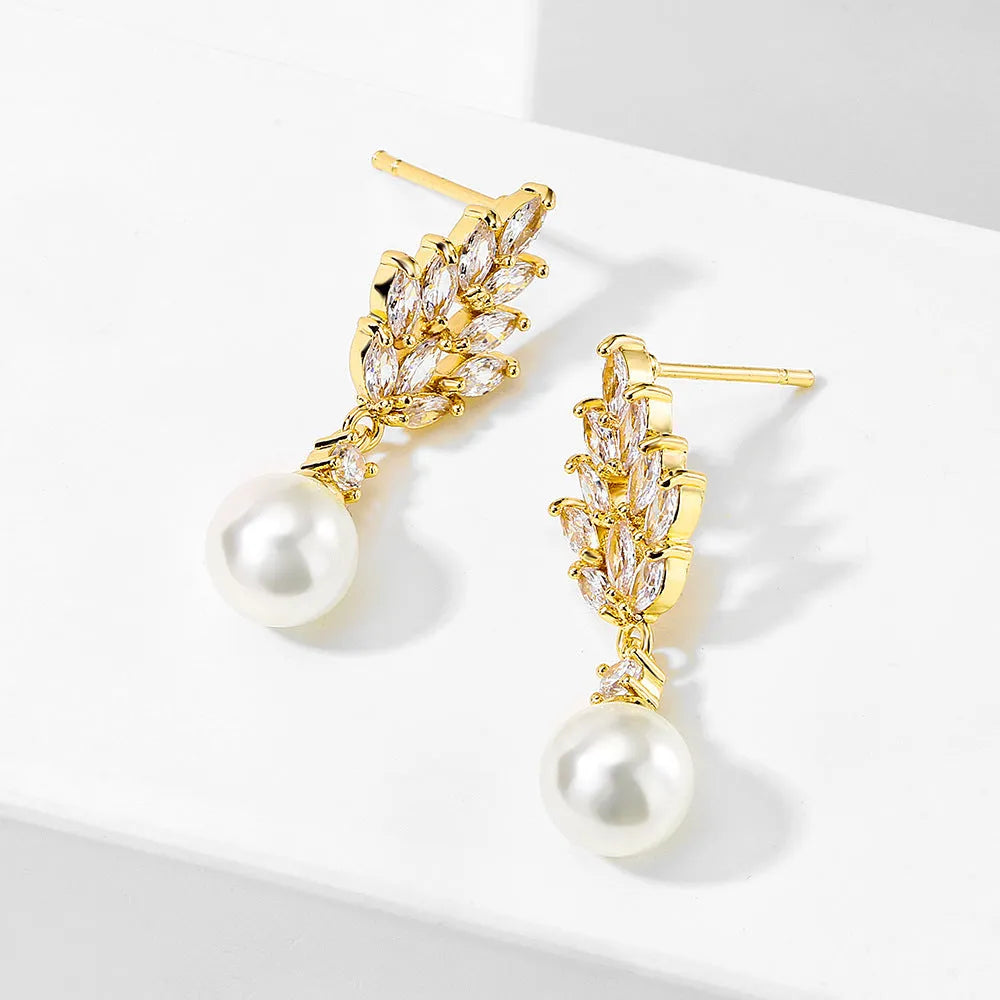 Geometric flower shaped earrings with micro inlaid zircon stones and pearl accents on a gold plated background.